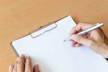 Elinde kalem olan adam kağıda yazmaya hazırlan.