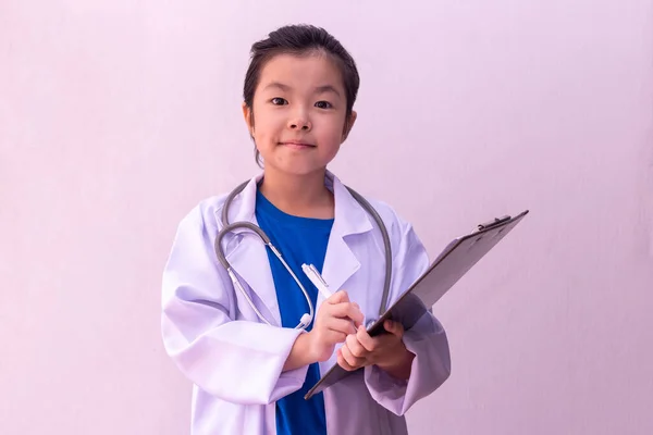 アジアの女の子再生医師とともに聴診器で手とクリップボードに書き込み — ストック写真