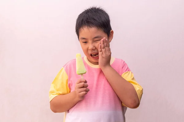 Азиатский Мальчик Сверхчувствительными Зубами Ест Цветное Мороженое Летом — стоковое фото