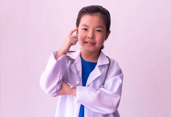 Asian girl playing doctor with stethoscope in hands.