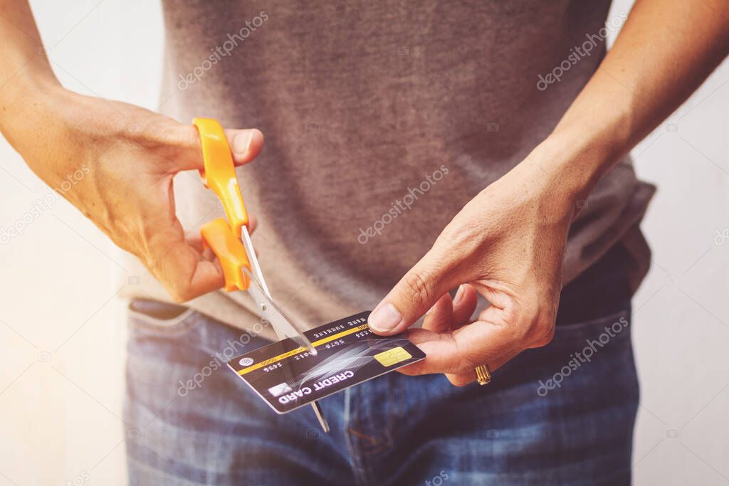 Man cutting credit card with scissors.