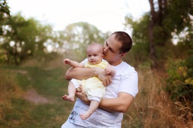 Baba ve küçük kız gün batımında doğada oynayıp gülüyorlar. Babalar Günü 'nün konsept fotoğrafı, ebeveynlik, babalık, sevgi, ilgi, bekar baba. Seçici odaklanma. Orta keskinlikte.
