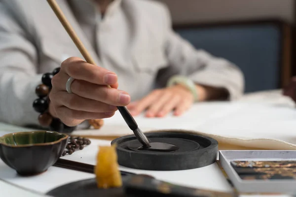 Près Homme Vêtu Une Veste Grise Trempe Pinceau Encre Pour — Photo