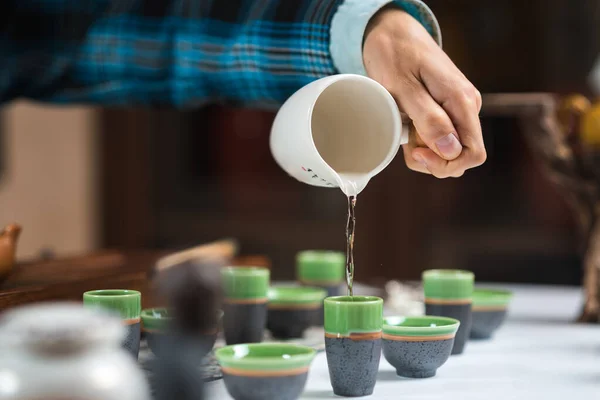 Un homme verse du thé chinois dans des tasses pour une cérémonie du thé — Photo