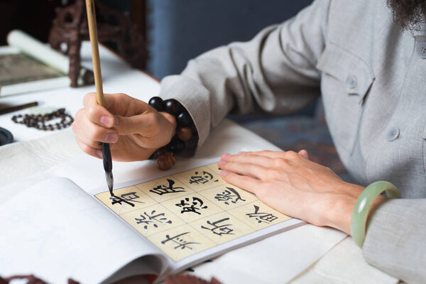 a man trines to write Chinese characters
