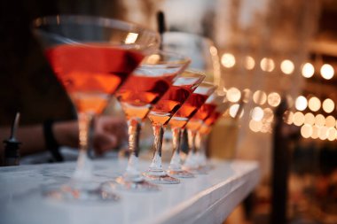 Masada alkollü bardaklar ve arka planda bulanık ışıklar..