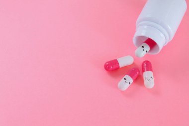 pembe ve beyaz kapsüller, gülücükler ve aşkla dolu pembe arka planda fotokopi alanı ile