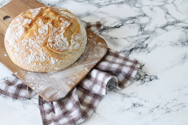 Круглый ржаной хлеб для нарезки на деревянной деревенской доске с мукой
