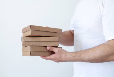 Kurye, eko-çözünebilir kutularda paket yiyecek getiriyor. Karantina altında teslimat hizmeti, Coronavirus covid-19 salgını. Teslimatçının elleri yakın plan.