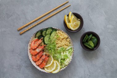 Yemek çubukları üst görüşlü Asya salatası. Gri taş arka planda karides kasesi. Sağlıklı ve dengeli gıda kavramı