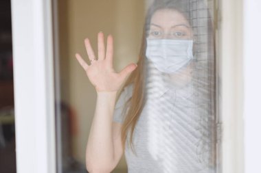 Pencerenin yanındaki bilgisayar başındaki kız, Coronavirus, covid-19.