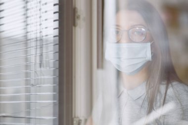 Pencerenin yanındaki bilgisayar başındaki kız, Coronavirus, covid-19.
