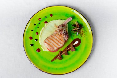 Mantarlı et, yeşil tabakta restoran yemeği.