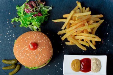 Etli hamburger ve soslu patates kızartması.