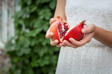 Bir kızın elinde bir narın iki yarısı.