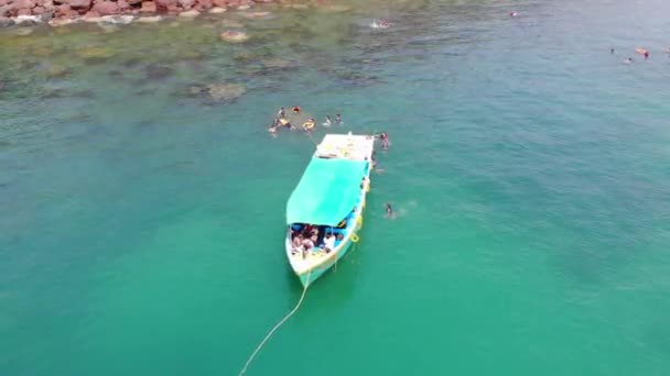 Barco flotando en el océano alrededor de la gente nadando en South Goa Beach, India - Vista aérea — Vídeos de Stock