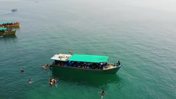 南ゴアビーチで水泳をする人々の周りの海に浮かぶボート-エアラルビュー — ストック動画