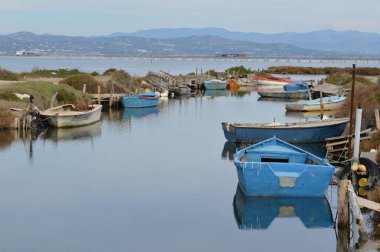 Bir lagünün kıyısında terk edilmiş küçük eski tekneler.