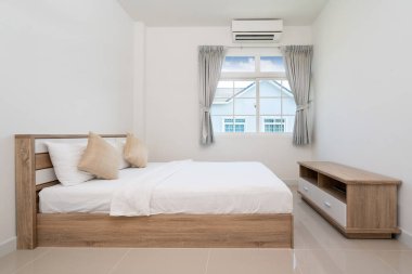 Yatak odası, villa, daire ve apartmanda tahta yatak ve televizyon konsolu.