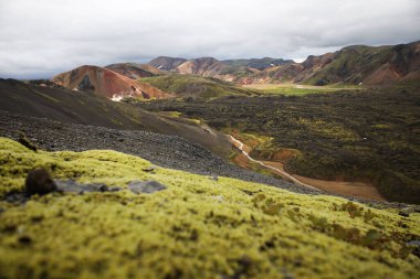 İzlanda parkında bulutlu bir gökyüzünün altındaki renkli dağlar Landmannalaugar