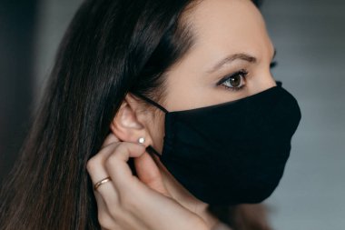 Esmer kadın Coronavirüs salgını yüzünden tıbbi maske takıyor. Virüsü nasıl durduracağını düşünüyor.. 