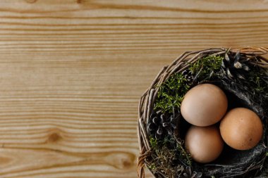 Paskalya doğal yumurtaları sarı doğal ahşap arka planda sepette. sağ taraf
