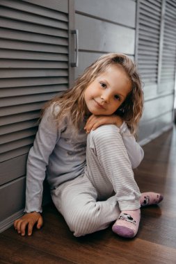 Karantinada okula gitmeyen ve gülümseyen küçük bir kız çocuğu.