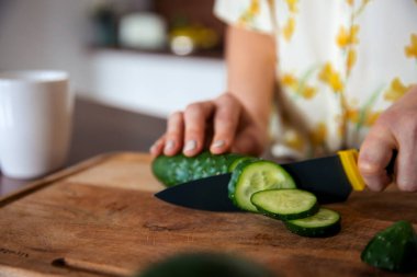 Bıçaklı kadın sebze doğruyor. Yemek pişirmek için çevre dostu ürünler kavramı