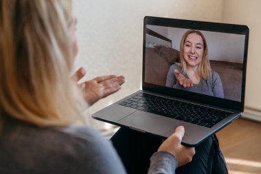 Bir kadının arkadaşlarıyla video konferansında planlar hakkında konuşmasının arka planda kalan kısmı. Video görüşmesi için çok ırklı dizüstü bilgisayar kullanılıyor. 