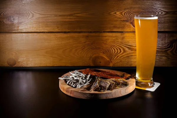 木製の背景に魚のミックスプレートとプレミアムクラフトビールグラス — ストック写真