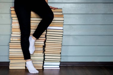 Dağ gibi kitap arşivlerinde oturan kadın. Beyaz çorapların üstünde bacaklar