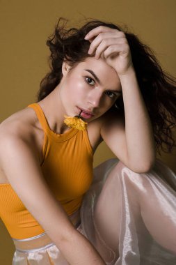 Sarı arka planda neon etekli çiçekli bir kız.