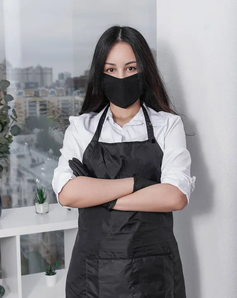 Girl in a black mask, gloves and apron