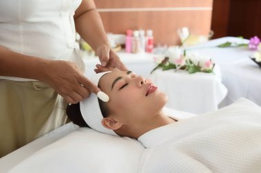 Sağlık, güzellik ve rahatlama konsepti - kaplıcadaki beyaz diş ipiyle masaj yaptıran genç bir kadın