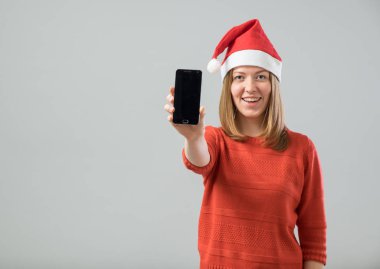 Smartphone gösterilen Noel Baba şapkası olan kadın