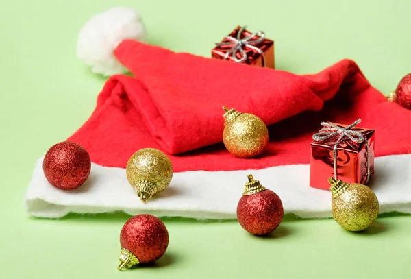 Vánoční dekorace sada kuliček, dárky a Santa klobouk — Stock fotografie