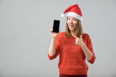 Smartphone gösterilen Noel Baba şapkası olan kadın