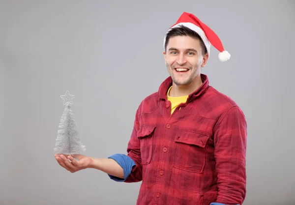 サンタ クロースの帽子とクリスマス ツリーと流行に敏感な男 — ストック写真