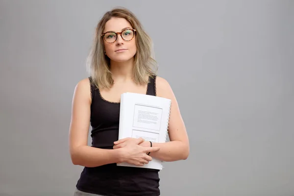 Estudante menina com óculos segurando um livro — Fotografia de Stock