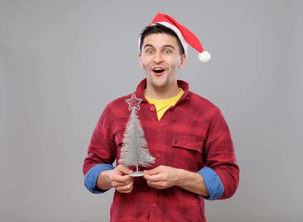 サンタ クロースの帽子とクリスマス ツリーと流行に敏感な男 — ストック写真