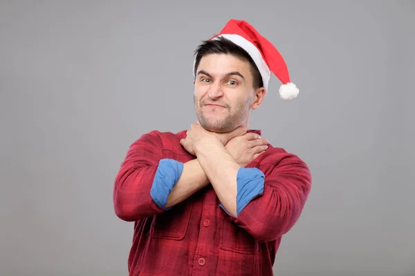 Porträt eines aufgebrachten jungen Mannes mit rotem Weihnachtsmann-Hut — Stockfoto