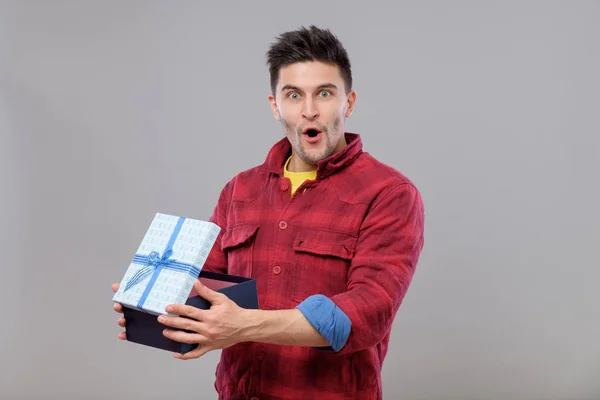 Счастливый молодой человек с подарком — стоковое фото