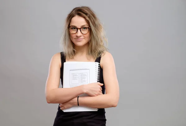 Estudante menina com óculos segurando um livro — Fotografia de Stock