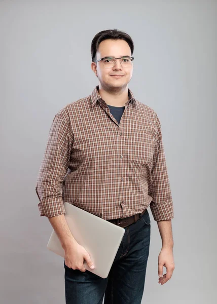 Случайный молодой человек в рубашке с ноутбуком — стоковое фото