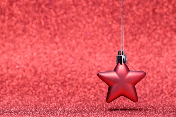 Small red Christmas star on glitter background — Stock Photo, Image