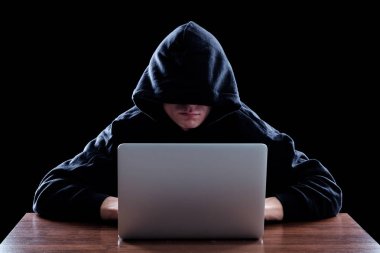 Karanlık bir defter önünde oturan hoody hacker