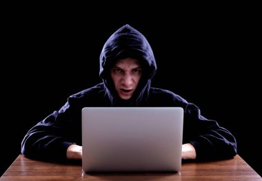 Karanlık bir defter önünde oturan hoody hacker