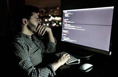 Yazılım geliştirici bilgisayarda karanlık ev ofis