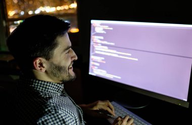 Yazılım geliştirici bilgisayarda karanlık ev ofis