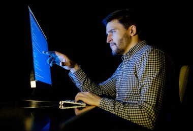 Yazılım geliştirici bilgisayarda karanlık ev ofis